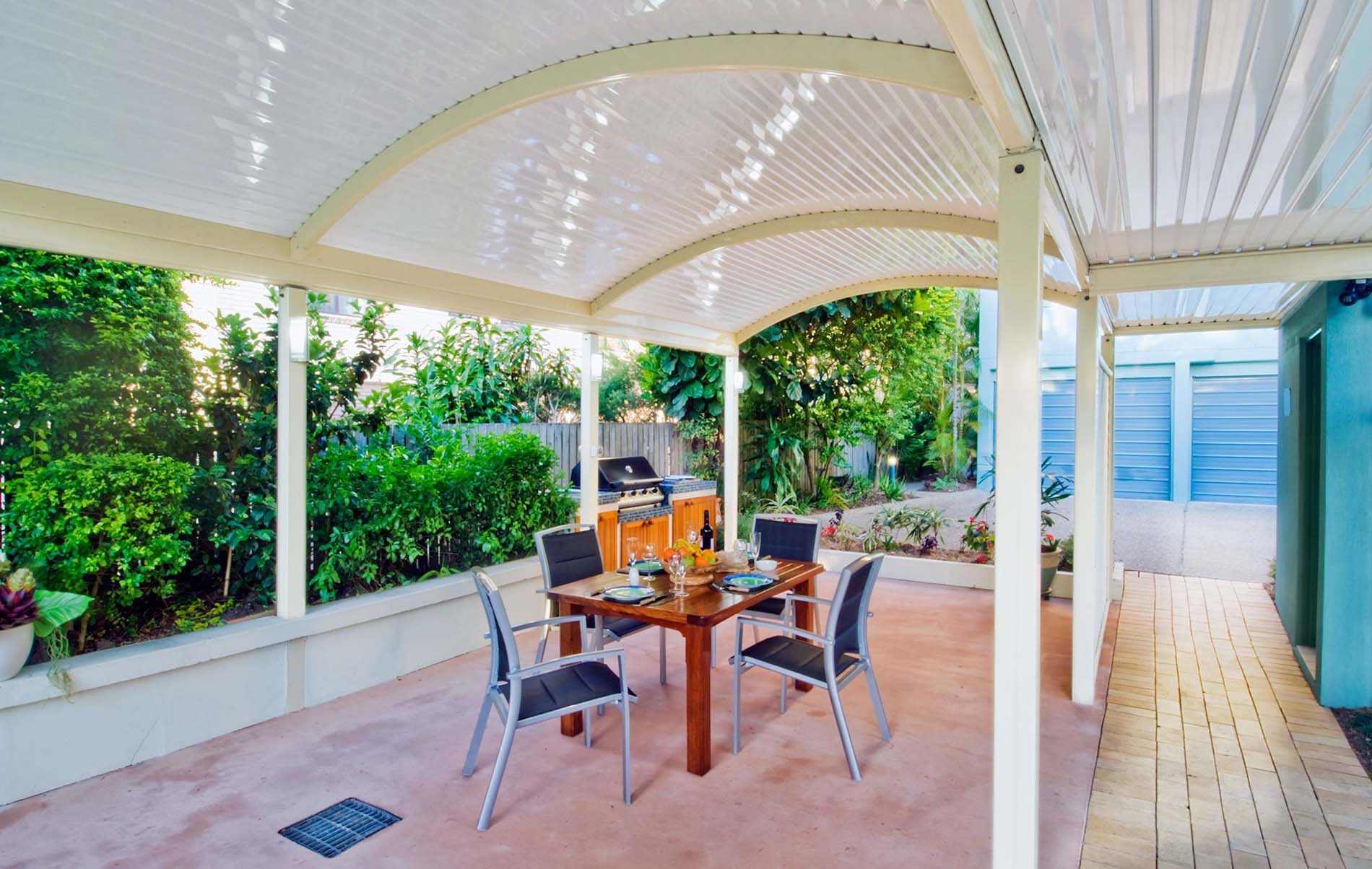 Curved roof patio with integrated lighting and outdoor seating in Melbourne backyard