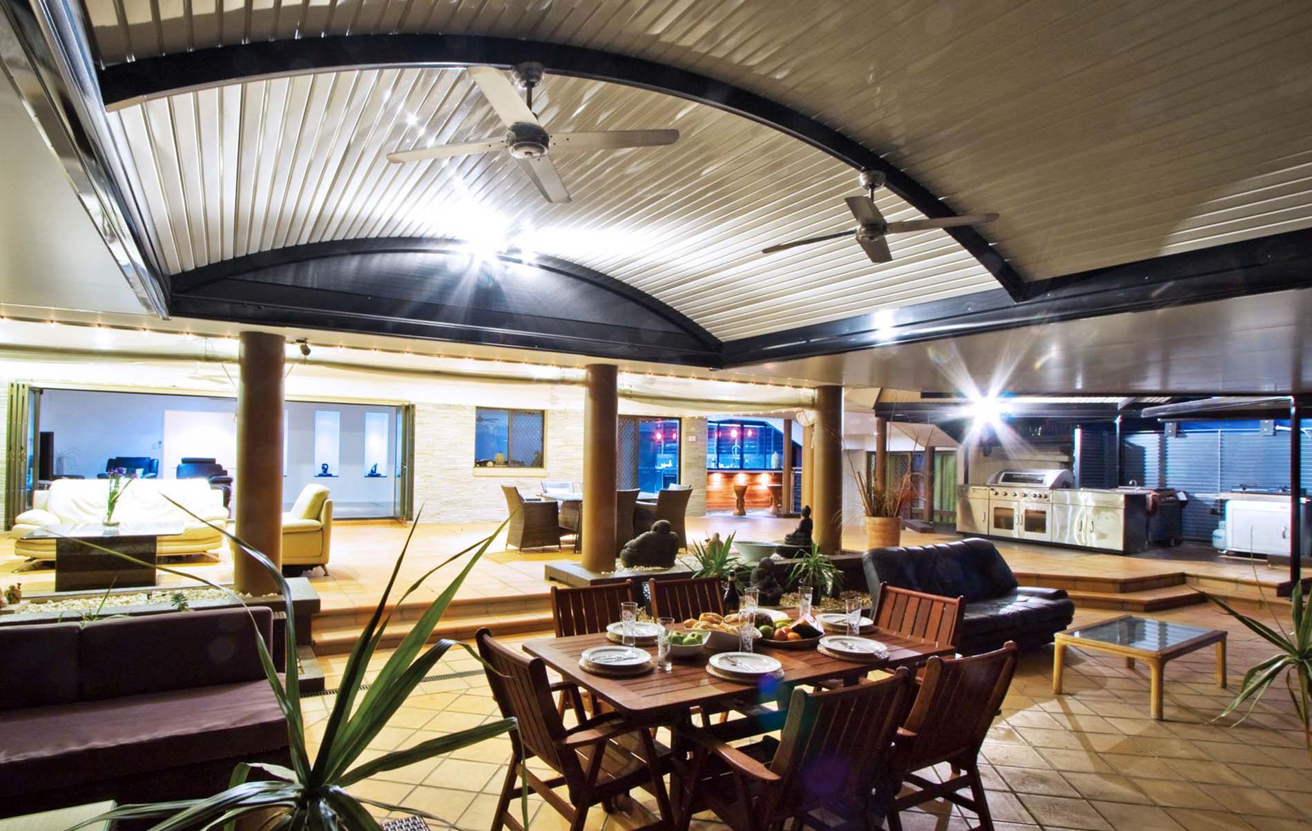 Curved patio with timber posts and translucent roofing panels in a modern backyard