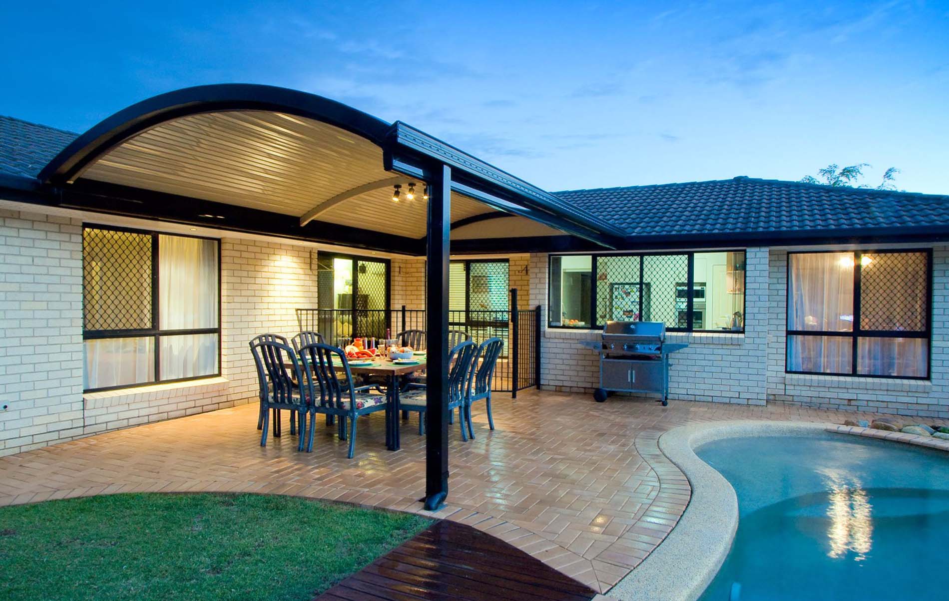 Stylish curved roof patio attached to brick home