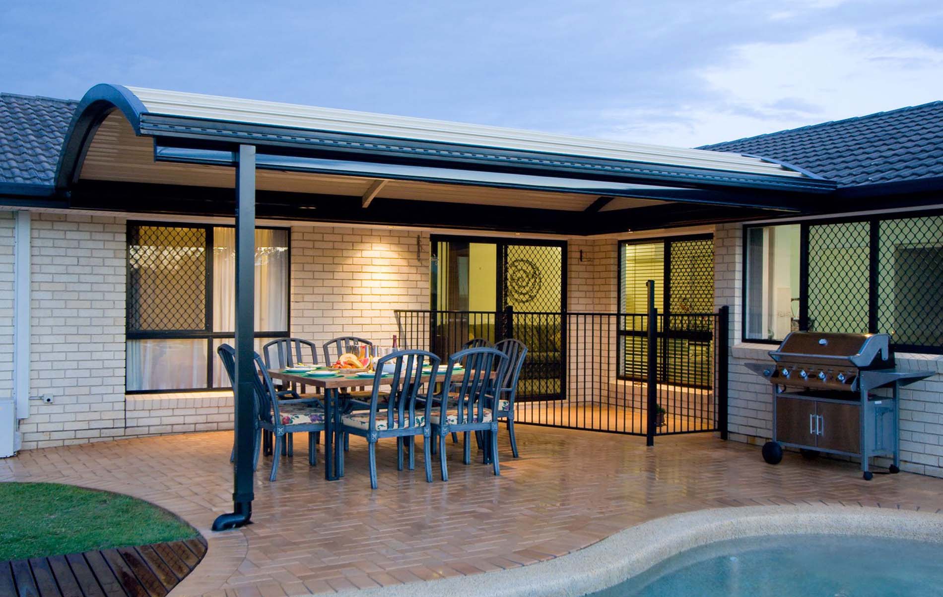 High gloss steel curved patio roof with surrounding landscaped garden