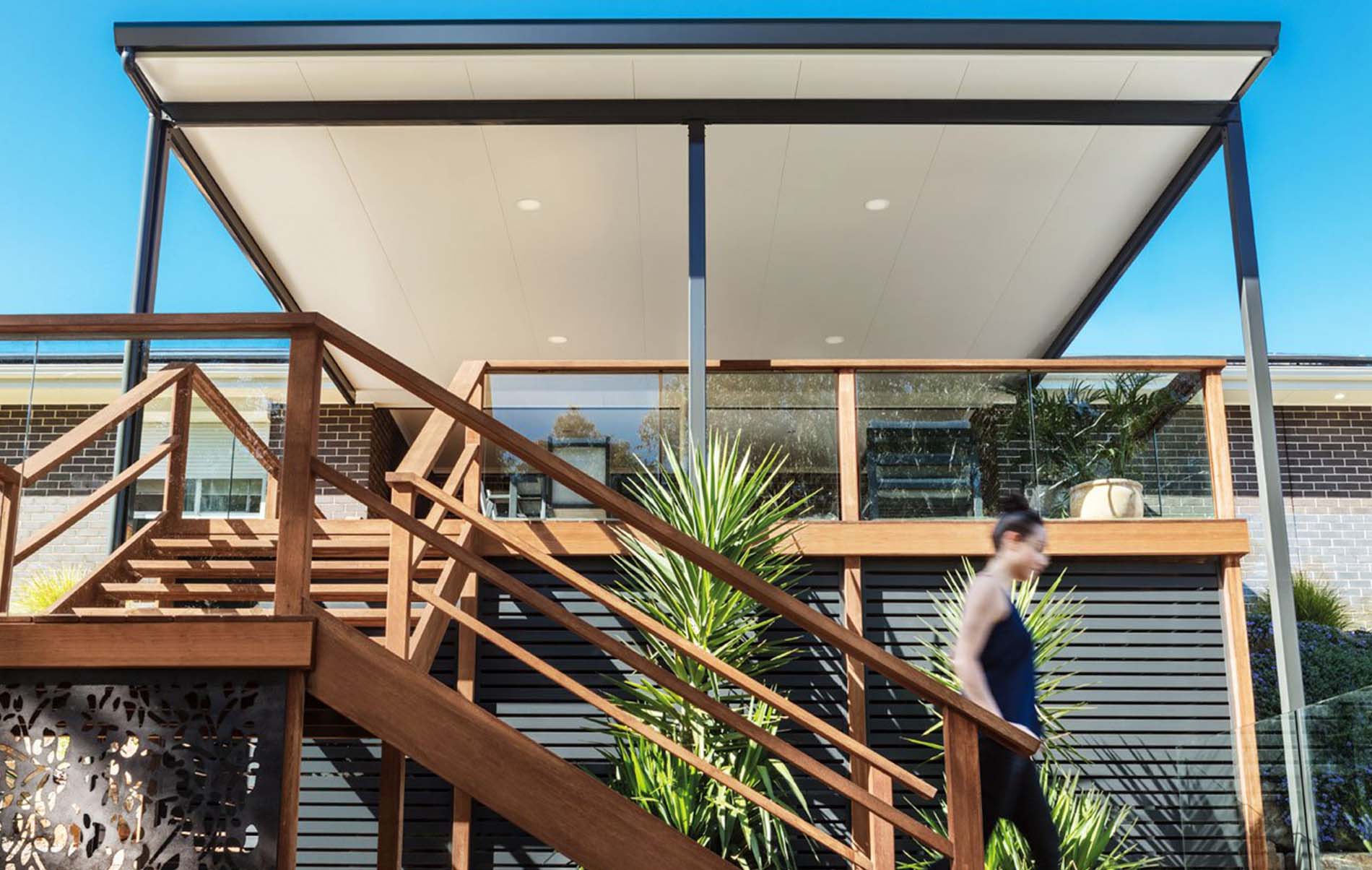 Contemporary flat patio design with clear roofing panels and garden view