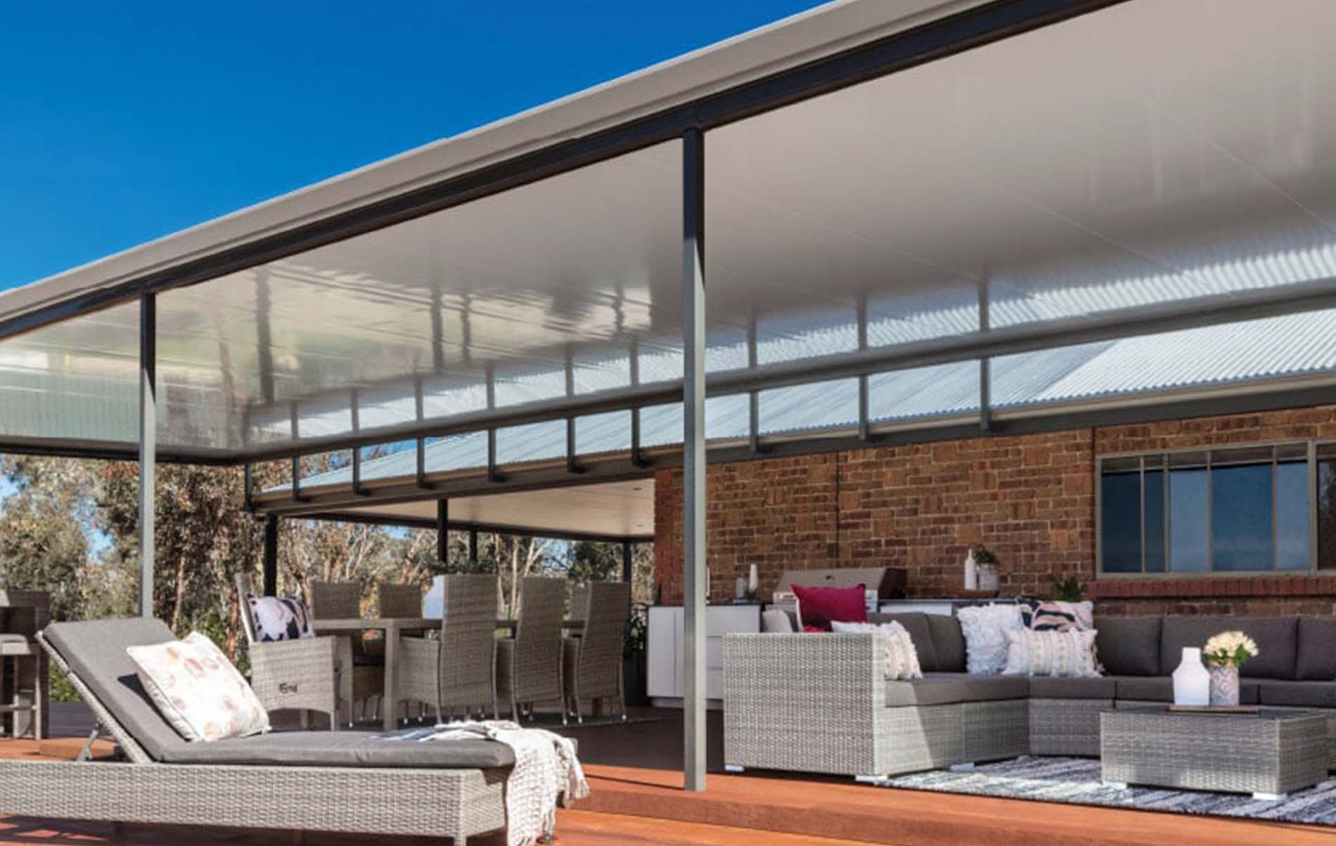 Contemporary outdoor patio featuring Stratco Cooldek insulated flat roof panels, complemented by integrated lighting and ceiling fans for enhanced comfort and style.