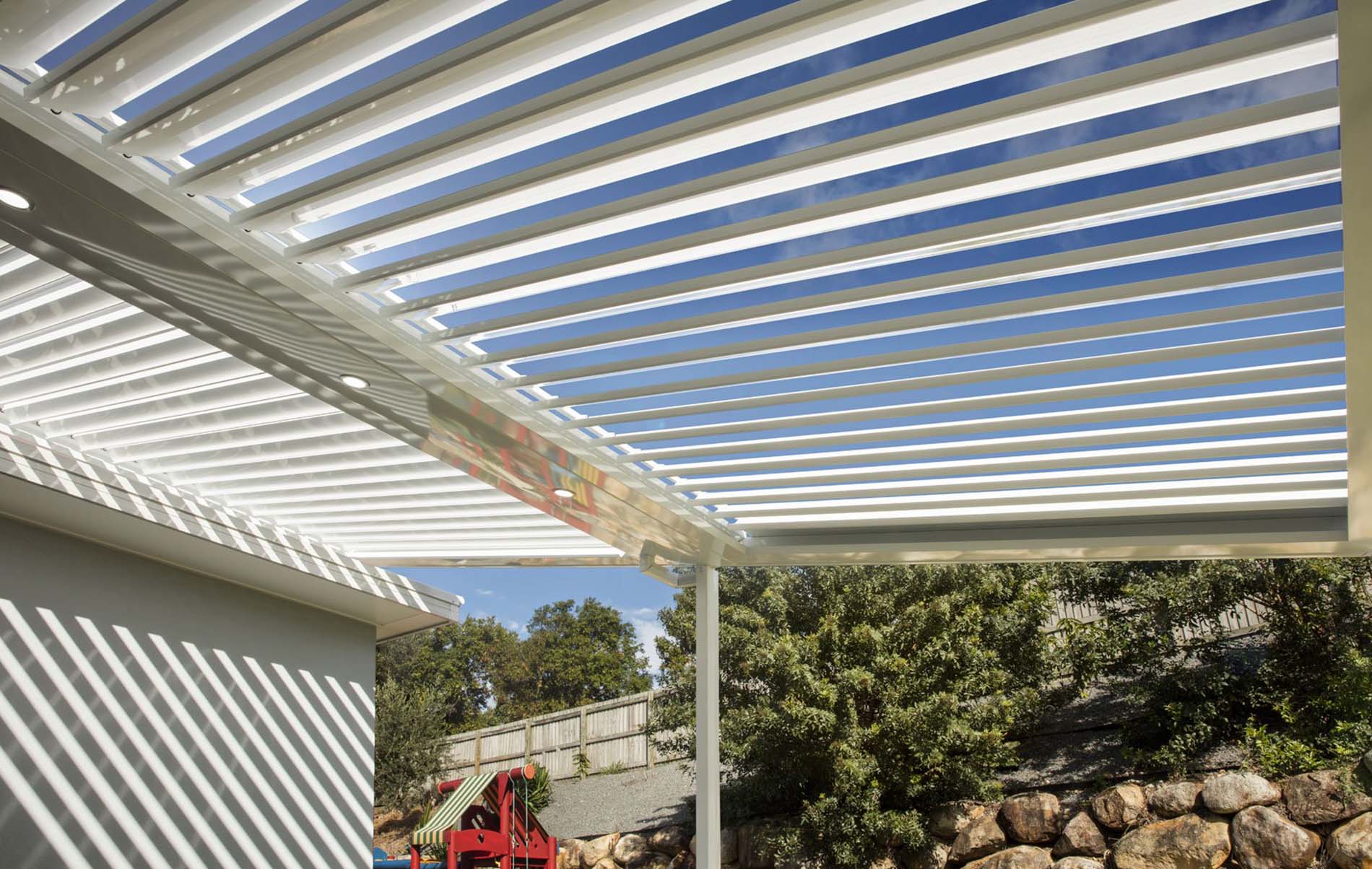 Outdoor dining area with adjustable louvre roof and timber-look aluminium frame