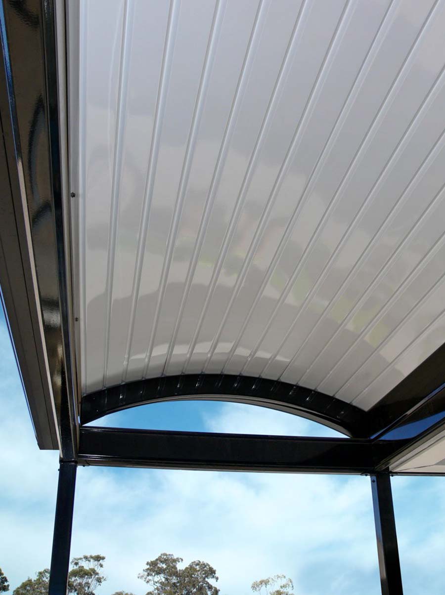 Vertical image showing curved steel patio roof over outdoor entertaining area